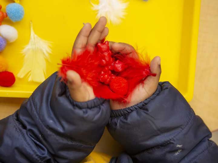 A young boy holding materials for an activity