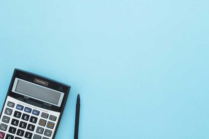 Calculator and pen on a blue background.