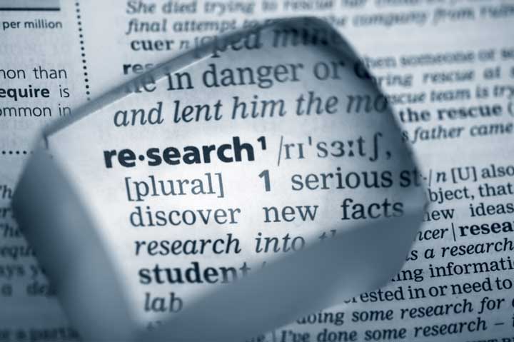magnifiying glass highlight the word research in the dictionary.