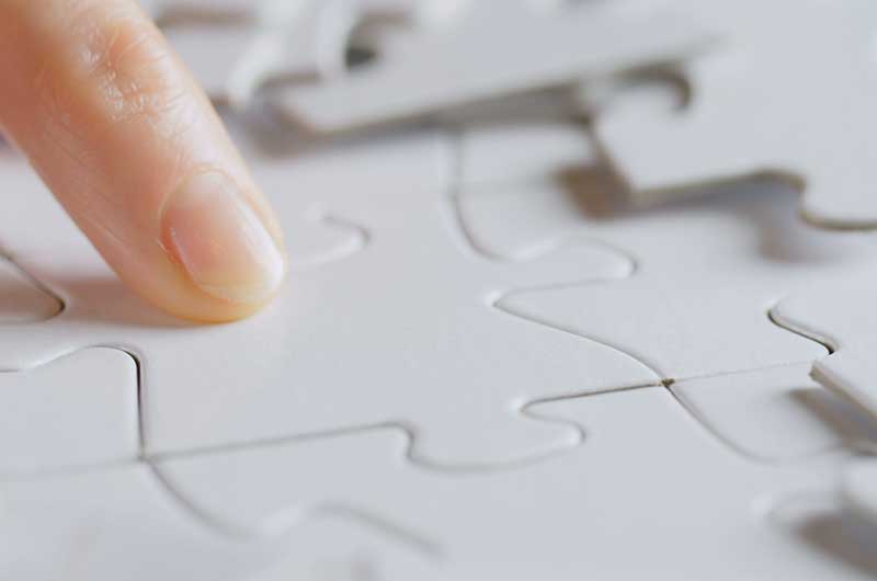 A finger pointing at puzzles pieces